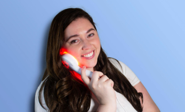 Woman using reVive Light Therapy Clinical Anti-Aging device on face
