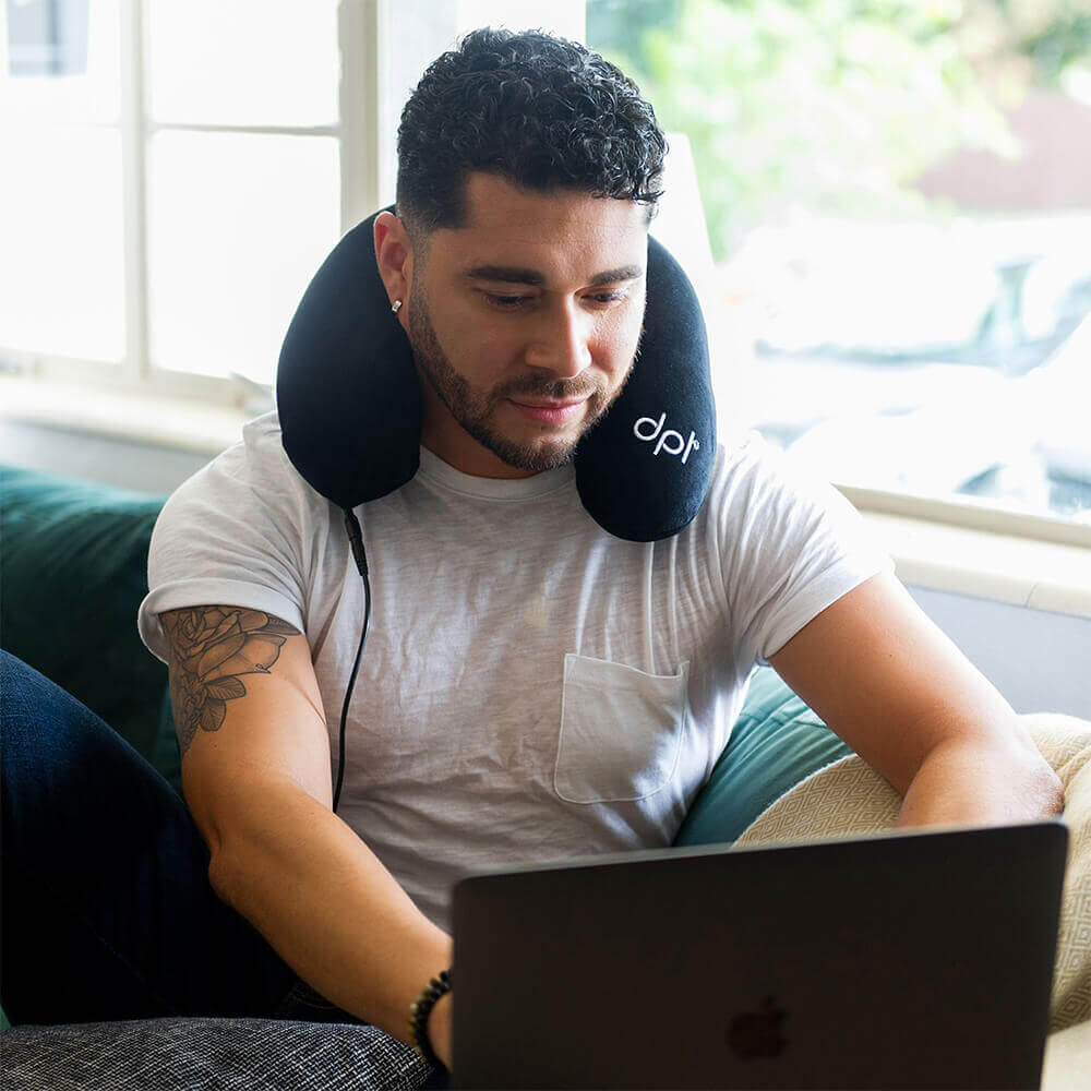 Man on Computer Using Neck pillow