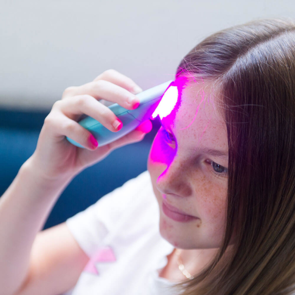 Girl using Essential LED Light Acne Treatment