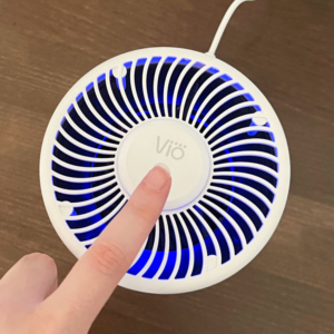 finger pressing power button on Vio Personal Air Purifier