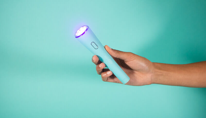 Hand holding reVive Light Therapy Spot device