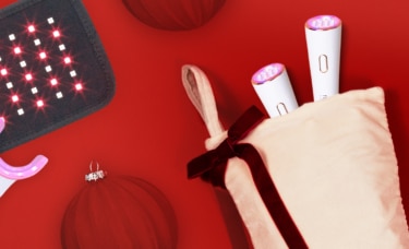 A hero image of reVive Light Therapy and dpl light therapy products on a red background with holiday accessories scattered around.