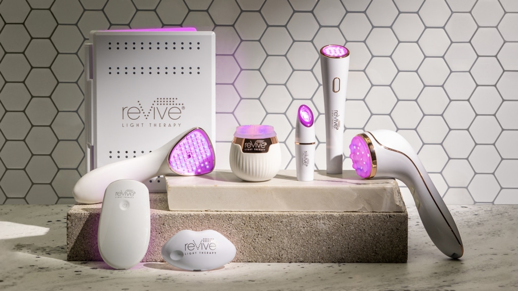 reVive Light Therapy's Lux Collection devices in front of a tile background. The lights of the devices are all on.