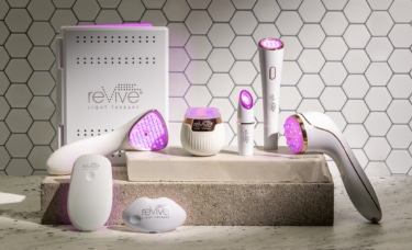 reVive Light Therapy's Lux Collection devices in front of a tile background. The lights of the devices are all on.