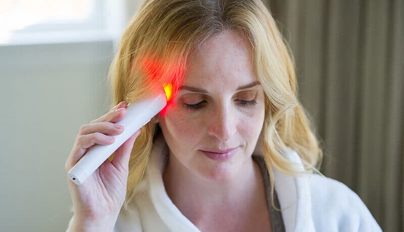 woman using revive light therapy glo on her crow's feet